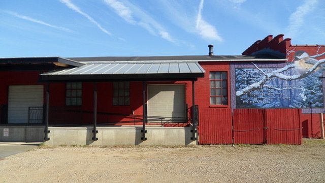 The Ignertia Building, red brick exterior with loading dock and mural